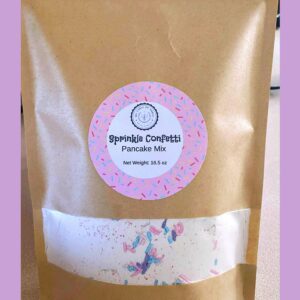 A brown bag of Sprinkle Confetti Pancake Mix from My Table of Three Bakery